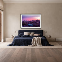 Eden Twofold Hush framed print in black with a white mat, above a navy linen bed in a bedroom