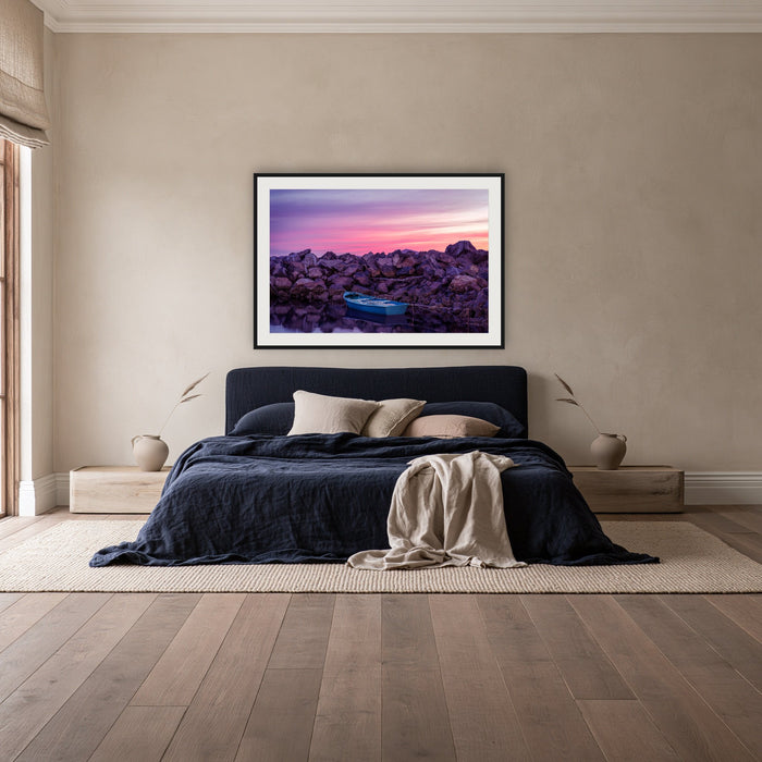 Eden Twofold Hush framed print in black with a white mat, above a navy linen bed in a bedroom