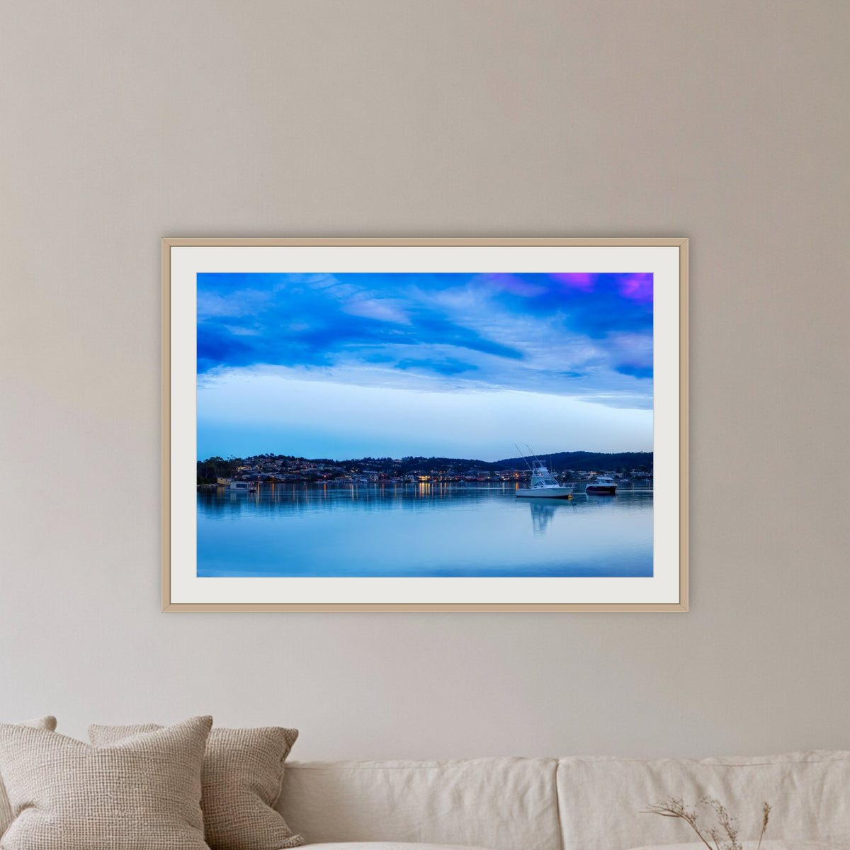 Dawn over Merimbula Lake framed print in oak with a white mat, in a lounge room