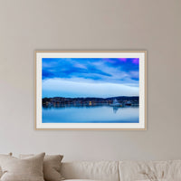 Dawn over Merimbula Lake framed print in oak with a white mat, in a lounge room