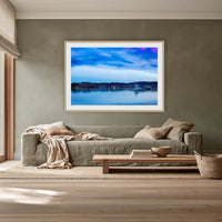 Dawn over Merimbula Lake framed print in oak with a white mat, above a sage linen sofa in a lounge room
