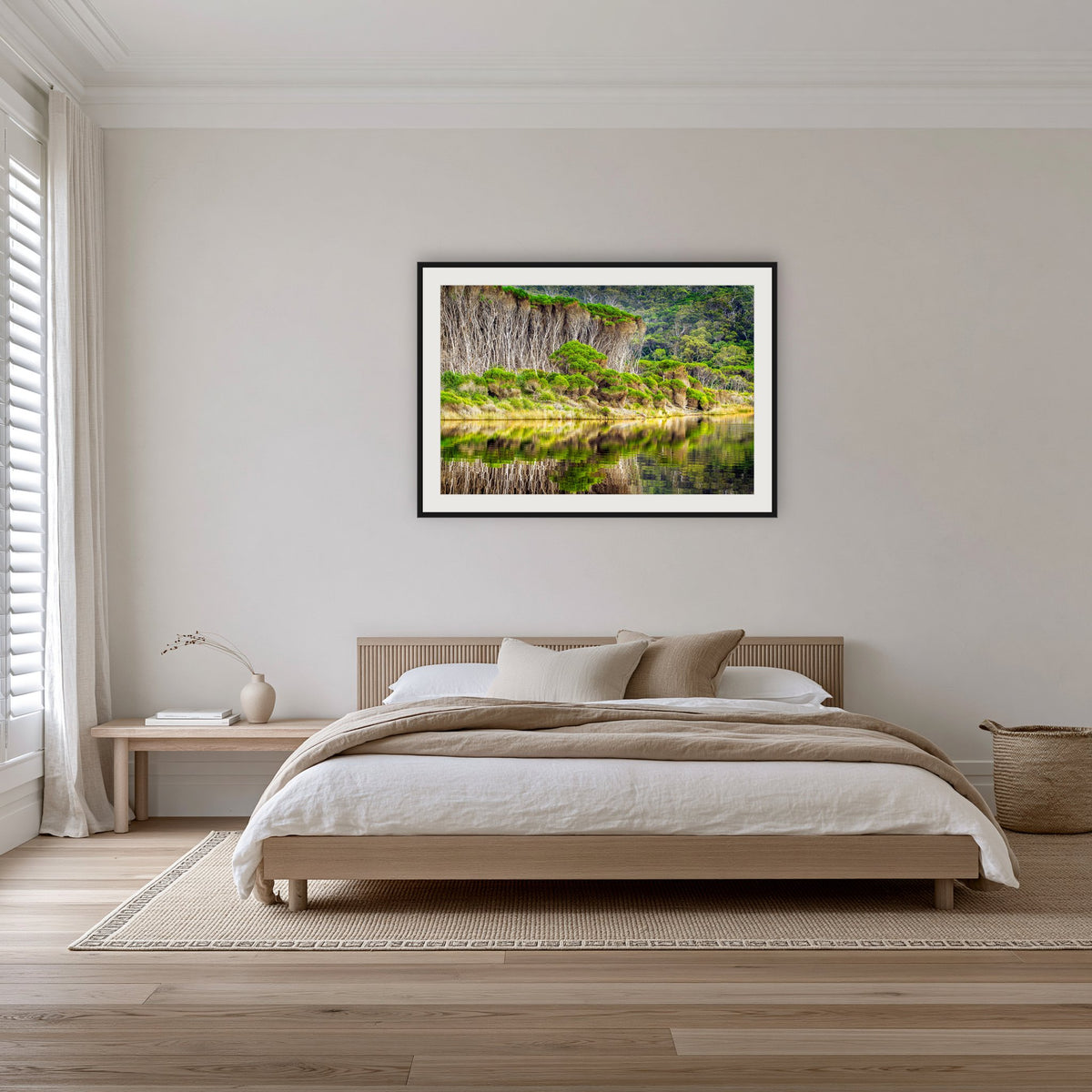 Bournda Lagoon's Serenity framed print in black with a white mat, on a coastal bedroom wall