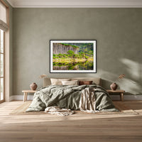 Bournda Lagoon's Serenity framed print in black with a white mat, above a khaki linen bed against a green-grey wall in a bedroom