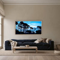 Wallagoot Lake and Sea at Blue Hour framed print in oak without a mat, above a navy linen sofa in a lounge room