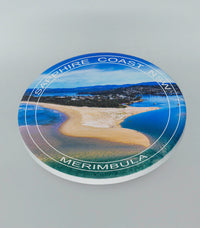 Single round ceramic coaster with location text — Merimbula Lake and Fishpen aerial, NSW